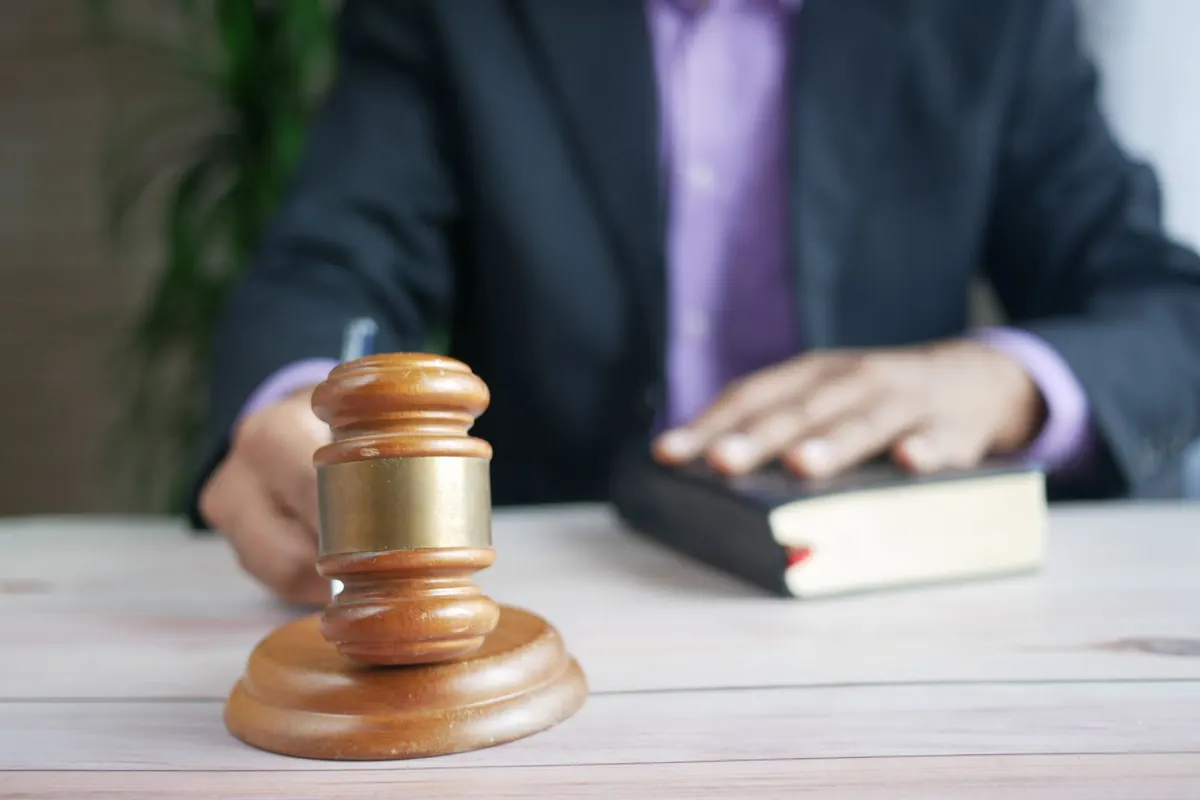 Judge's gavel resting beside a law book on a desk