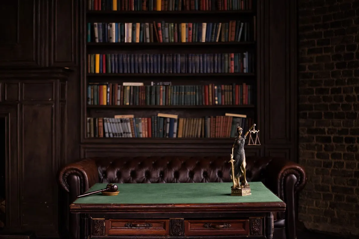 Law library with bookshelves, a gavel, and a Lady Justice statue