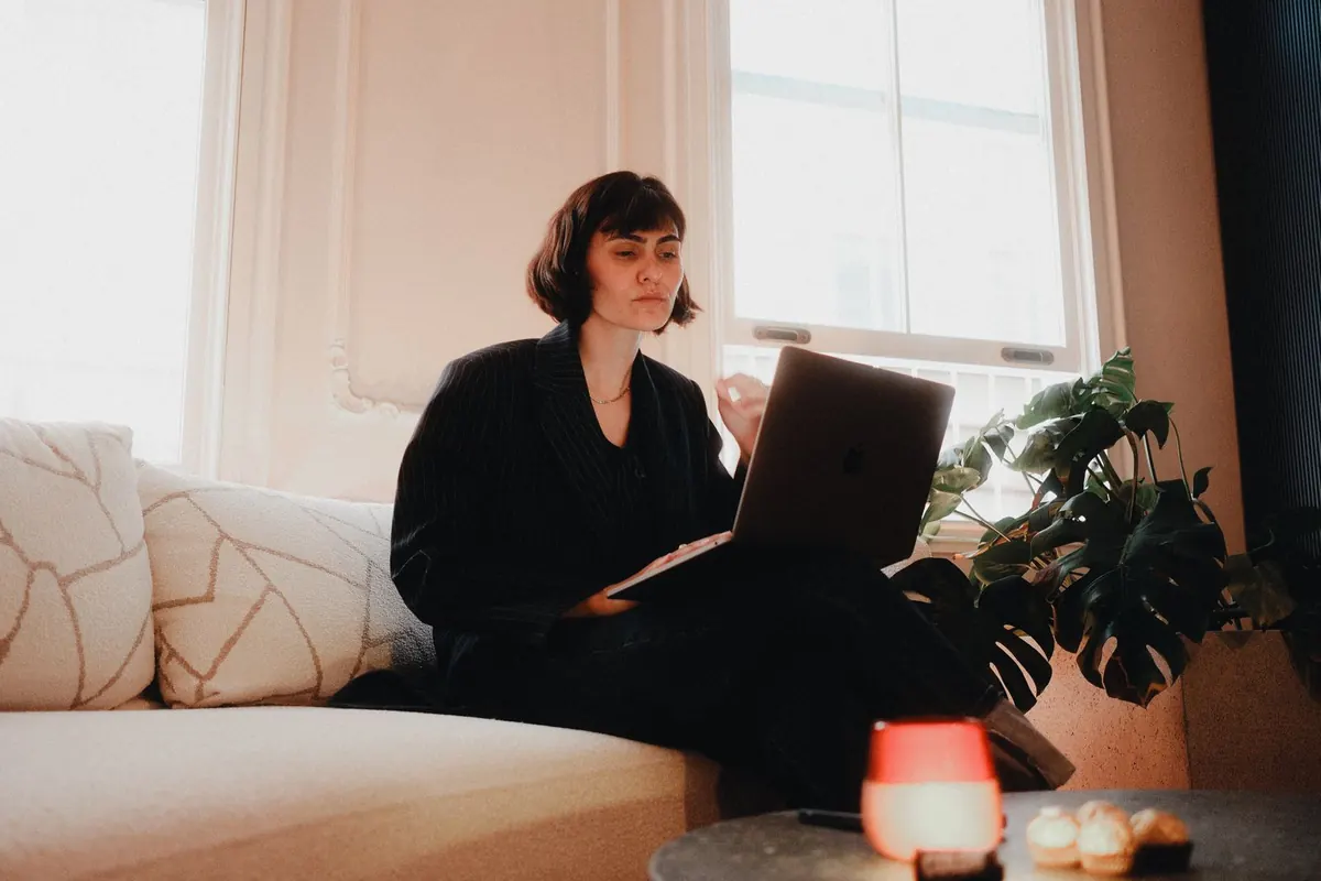 Professional working remotely on a laptop from a home living room